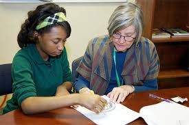 Young girl and older woman working together on school assignment